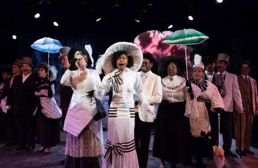 The cast of My Fair Lady, singing with umbrellas