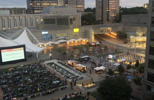 WeekEnder:  Movie screen with people sitting on chairs and blankets, food trucks on lower square